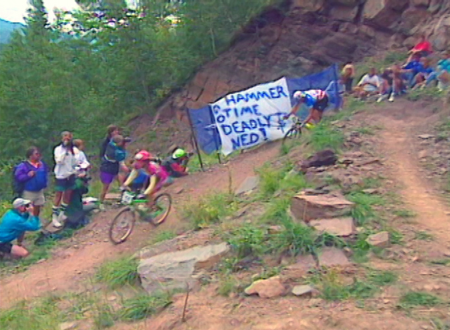 mountain bikers riding down a switchback